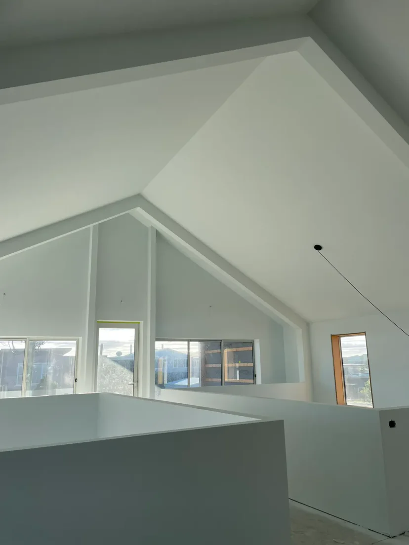 The plastered double-height void of Shed Home 03 with highlight windows