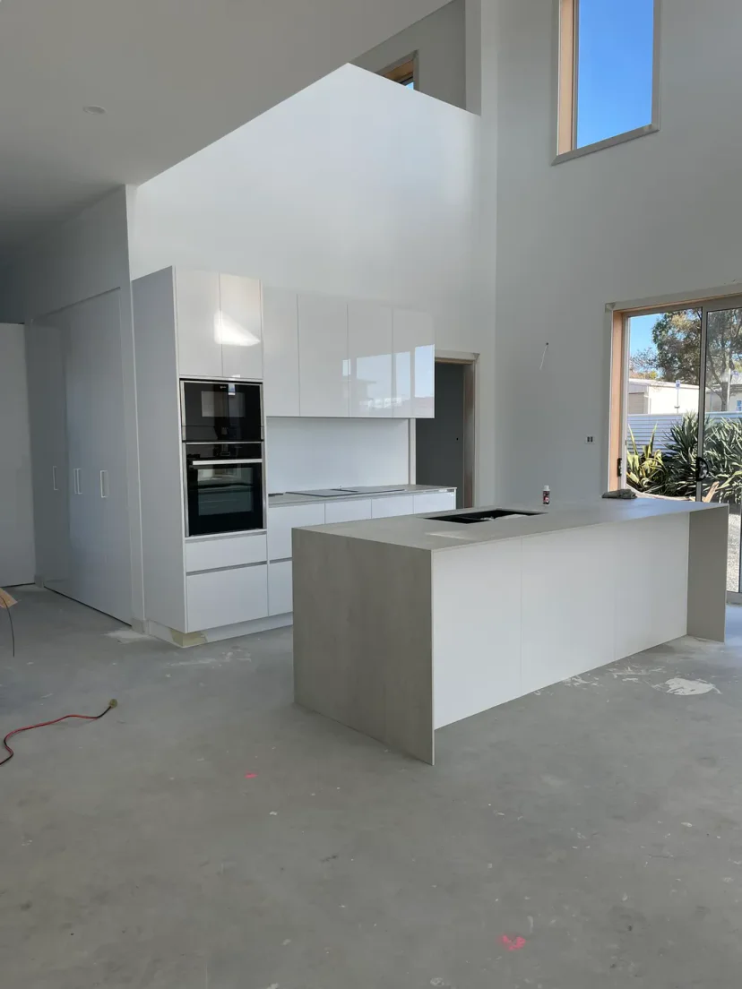 The finished white kitchen under the double-height ceiling