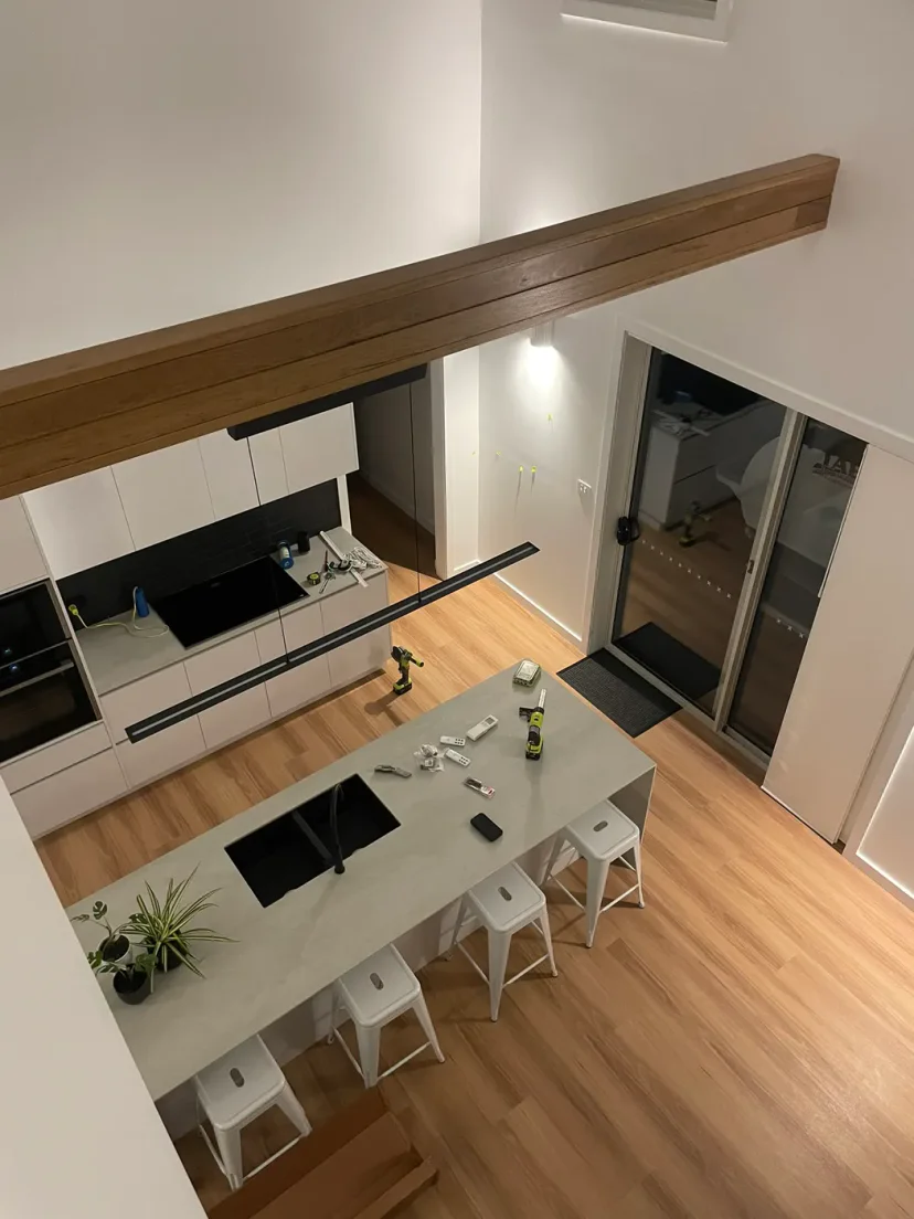 Looking down from the mezzanine over the kitchen island and timber beam